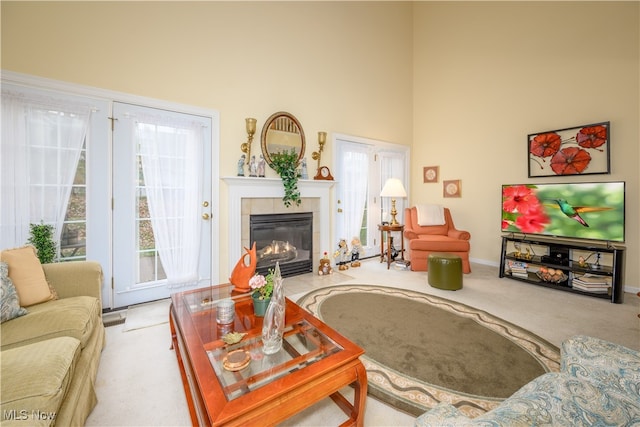 carpeted living room with a high ceiling and a tile fireplace