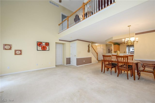 dining area with visible vents, stairway, carpet floors, baseboards, and a towering ceiling