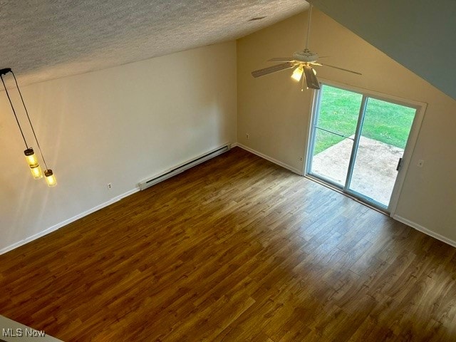 interior space featuring baseboard heating, a textured ceiling, lofted ceiling, and dark wood-type flooring