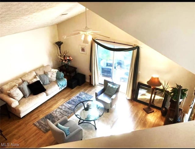 living room featuring ceiling fan, lofted ceiling, a healthy amount of sunlight, and light hardwood / wood-style floors