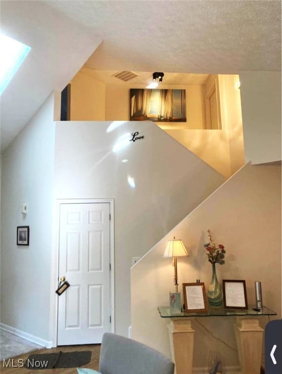 staircase with a textured ceiling and a skylight