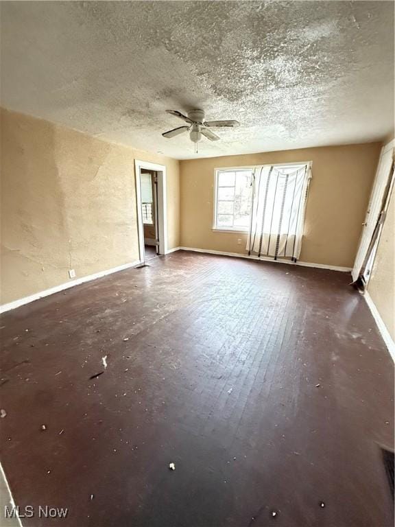 empty room with ceiling fan, dark hardwood / wood-style flooring, and a textured ceiling