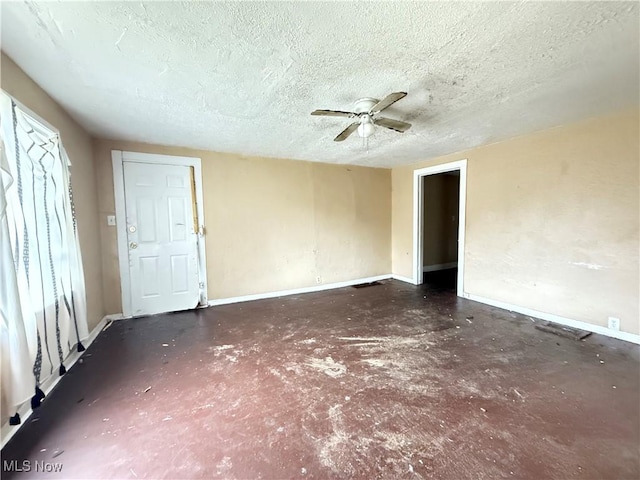 empty room featuring ceiling fan and a textured ceiling