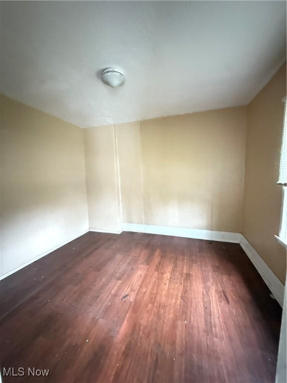 unfurnished room featuring dark hardwood / wood-style flooring