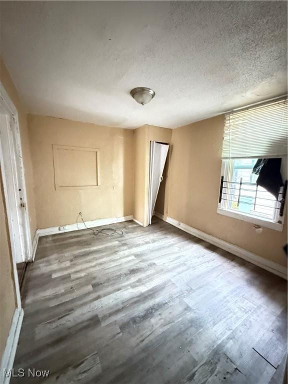 spare room featuring a textured ceiling and hardwood / wood-style flooring