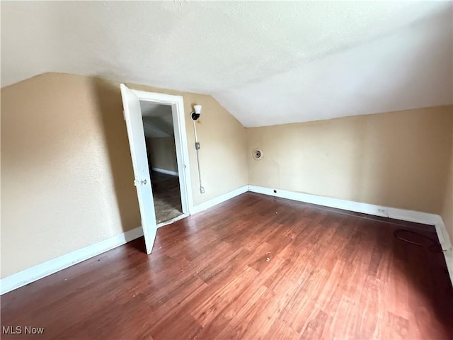 bonus room with wood-type flooring, a textured ceiling, and lofted ceiling