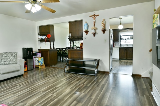 living room with dark wood-type flooring, ceiling fan, and sink