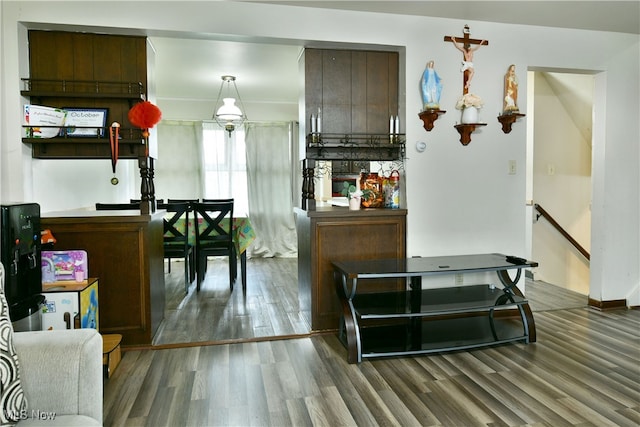 kitchen featuring dark brown cabinetry, pendant lighting, and dark hardwood / wood-style flooring