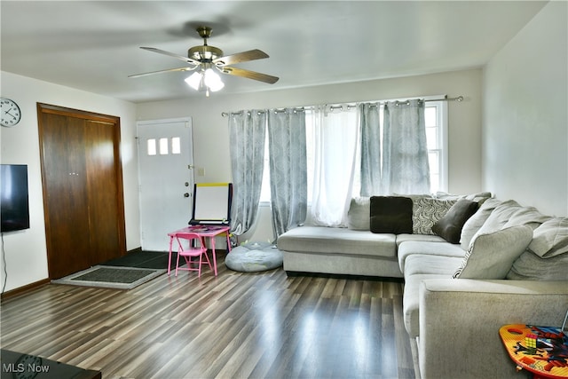 living room with dark hardwood / wood-style flooring and ceiling fan