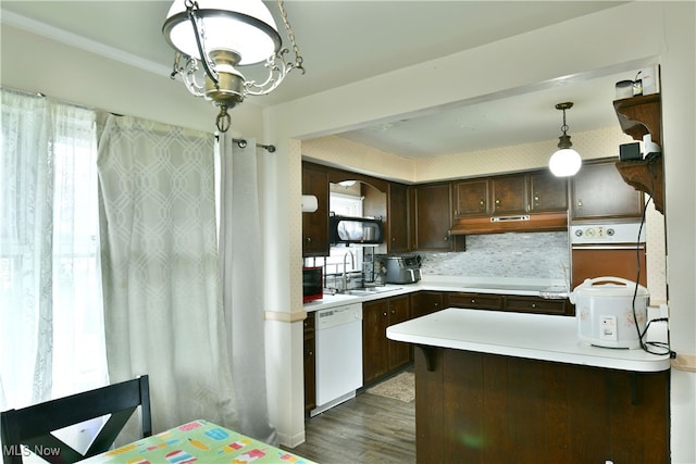 kitchen with white dishwasher, decorative light fixtures, backsplash, oven, and dark wood-type flooring