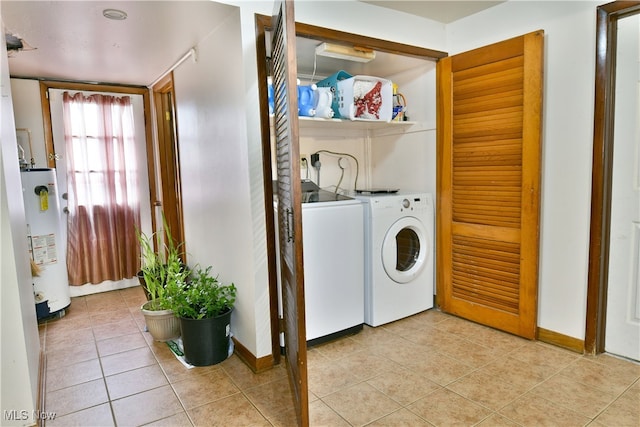 laundry area featuring light tile patterned flooring, gas water heater, and independent washer and dryer