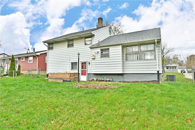 back of house with cooling unit and a lawn