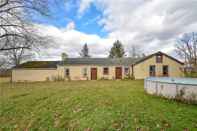 rear view of house featuring a yard