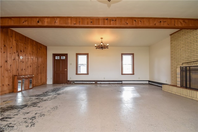 entrance foyer featuring wood walls, an inviting chandelier, and a brick fireplace