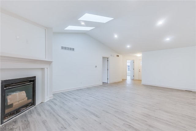 unfurnished living room with lofted ceiling with skylight and light wood-type flooring