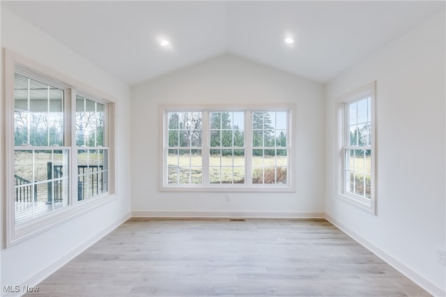 unfurnished room featuring light wood-type flooring and lofted ceiling