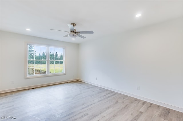 empty room with ceiling fan and light hardwood / wood-style flooring