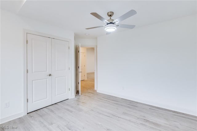 unfurnished bedroom with light hardwood / wood-style floors, ceiling fan, and a closet