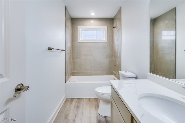 full bathroom featuring toilet, tiled shower / bath combo, vanity, and hardwood / wood-style floors