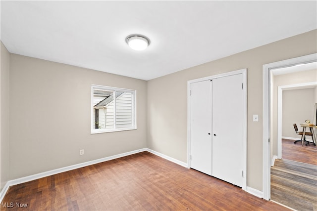 bedroom featuring dark hardwood / wood-style flooring and a closet