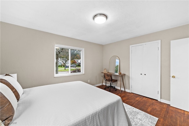 bedroom with dark wood-type flooring and a closet