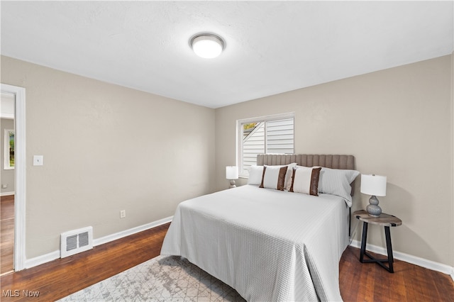 bedroom with dark hardwood / wood-style flooring