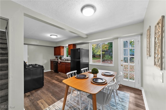 dining room featuring dark wood-type flooring, sink, and a healthy amount of sunlight