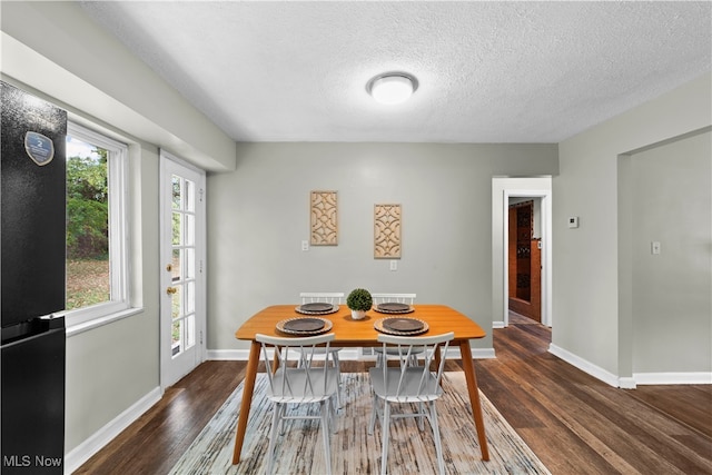 dining room featuring dark hardwood / wood-style flooring and a textured ceiling