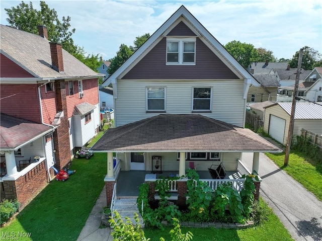 view of front of house with a front lawn, an outbuilding, and a porch