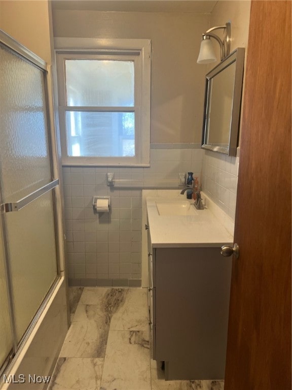 bathroom featuring vanity and tile walls