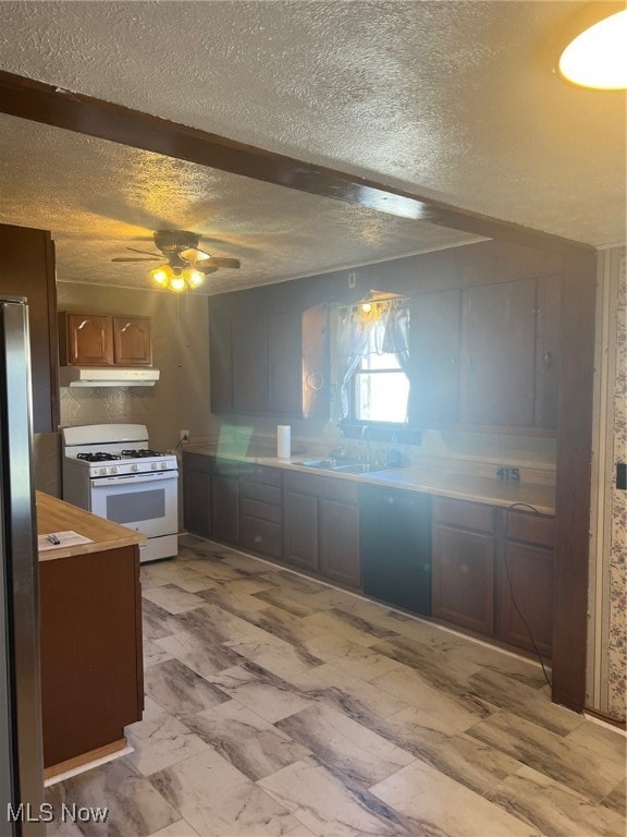 kitchen with white range with gas stovetop, a textured ceiling, ceiling fan, and sink