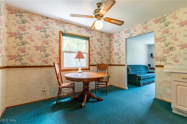 unfurnished dining area with ceiling fan, tile walls, and carpet