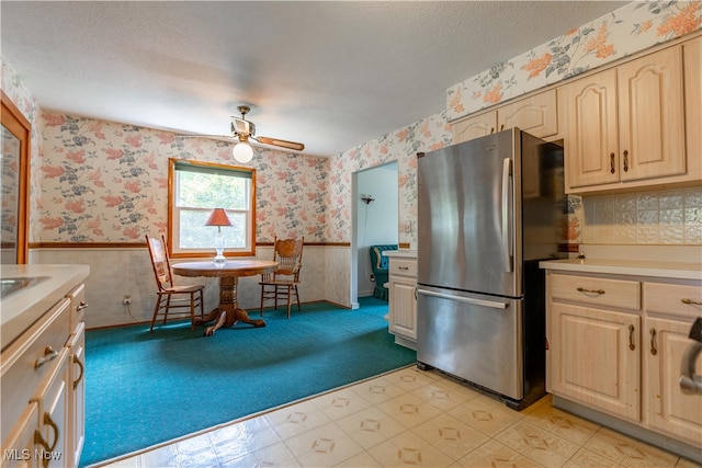 kitchen with ceiling fan, stainless steel refrigerator, a textured ceiling, and light carpet