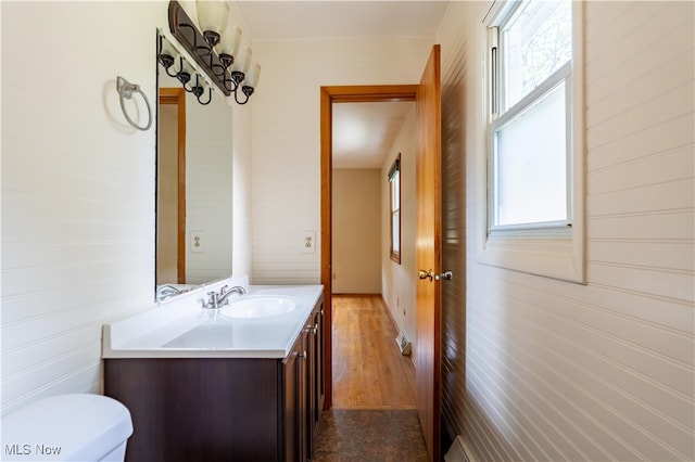 bathroom with hardwood / wood-style flooring, vanity, and toilet