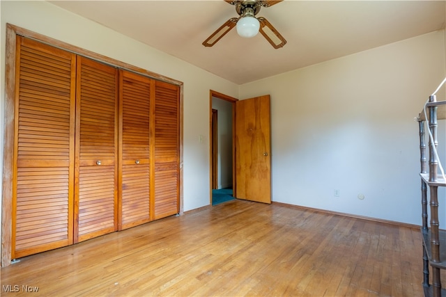 unfurnished bedroom featuring light hardwood / wood-style flooring, ceiling fan, and a closet