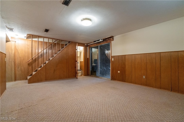 interior space with wooden walls and a textured ceiling