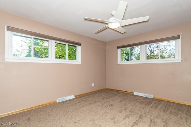 unfurnished room featuring carpet flooring, a wealth of natural light, and ceiling fan