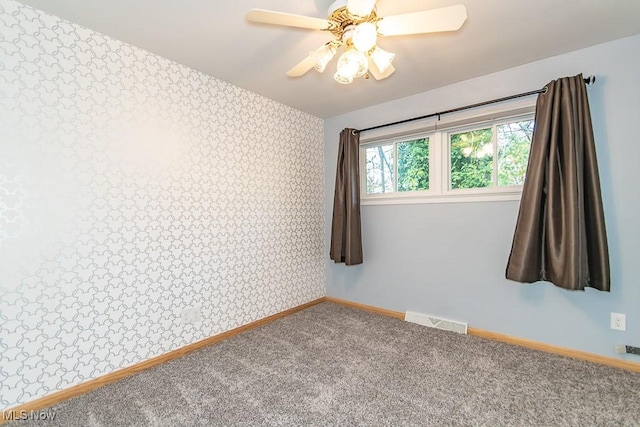 unfurnished room with ceiling fan and carpet