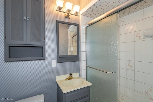 bathroom featuring vanity, toilet, and walk in shower