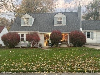 cape cod-style house with a front lawn and a garage