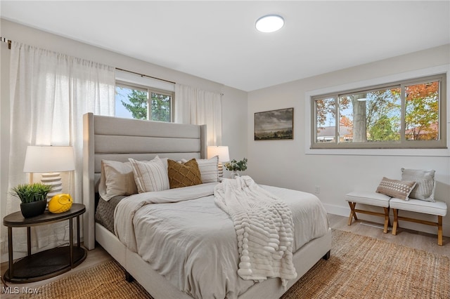 bedroom featuring multiple windows and hardwood / wood-style flooring