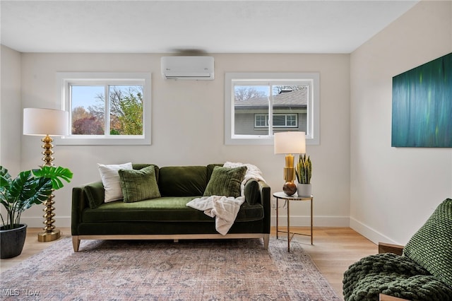 living area with light hardwood / wood-style floors, a healthy amount of sunlight, cooling unit, and a wall mounted air conditioner