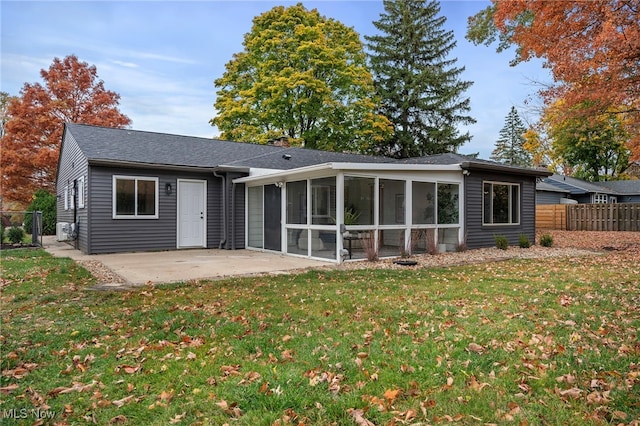 rear view of property with a patio, a sunroom, and a lawn