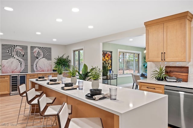 kitchen with a breakfast bar area, plenty of natural light, wine cooler, and dishwasher