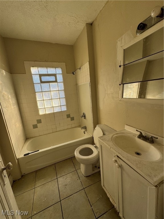 full bathroom with a textured ceiling, vanity, tile patterned floors, toilet, and tiled shower / bath combo