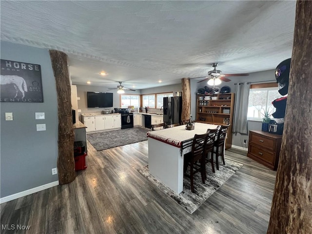 dining space with a textured ceiling, plenty of natural light, and dark wood-type flooring