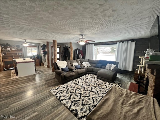 living room featuring ceiling fan, a healthy amount of sunlight, a textured ceiling, and hardwood / wood-style flooring