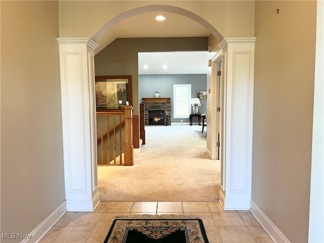 hallway with ornate columns and light carpet