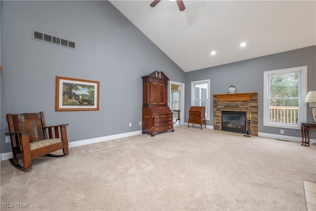 living area with light carpet, high vaulted ceiling, a fireplace, and ceiling fan