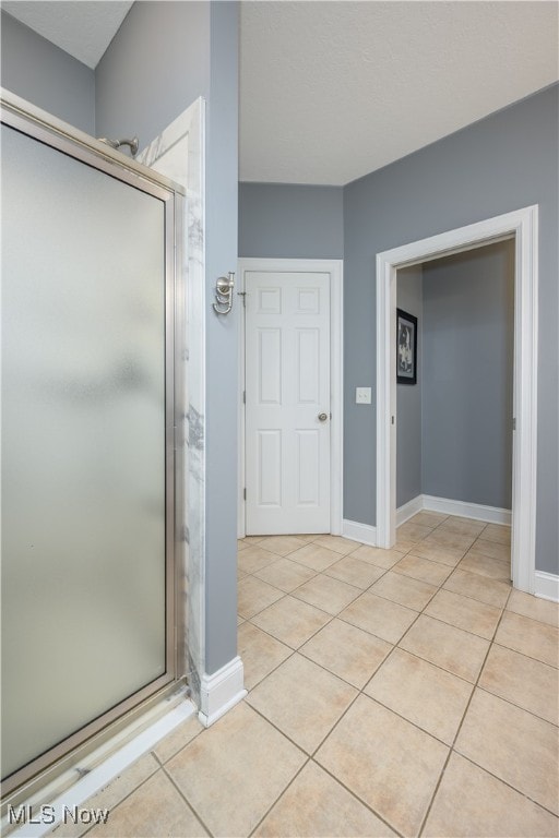 bathroom with tile patterned floors and an enclosed shower